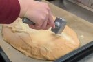 Mit einem Fleischklopfer wird die Eischnee- Salz- Kruste aufgeklopft