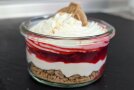 Schichtdessert in einem Glas mit Himbeeren und Spekulatius.
