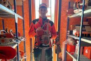 Maximilian Hutterer steht mit seiner Motorsäge in einem Schuppen.