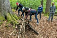 Die Teilnehmer bauen im Wald aus Ästen eine Kugelbahn