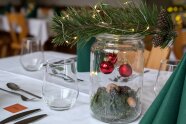 Auf einem gedeckten Tisch steht Weihnachtsdekoration.