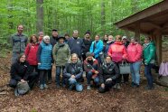 Mehrere Personen neben Hütte im Wald