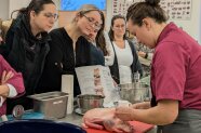 Fachlehrerin Veronika Gruber führt das Würzen, Füllen und Vernähen der Ente praktisch vor.