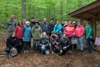 Mehrere Personen neben Hütte im Wald