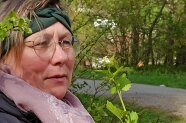 Frau hält in einer Hand eine Knoblauchsrauke.